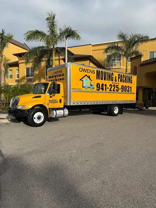 Professional moving crew loading furniture and boxes into a moving truck, demonstrating careful handling of household items.